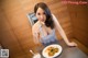 A woman sitting at a table with a plate of food.