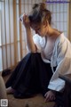 A woman sitting on the floor holding a cup of coffee.