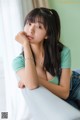 A young woman sitting on top of a white couch.