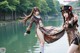 A couple of women standing next to a body of water.