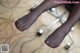 A woman's feet with red nail polish sitting on a chair.