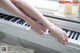 A woman's feet are sitting on a white piano.