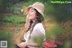 A woman in a straw hat sitting on a pile of hay.