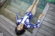 A woman laying on a wooden dock next to a pool.